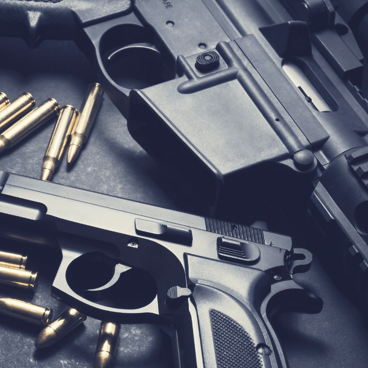 Two handguns with bullets laying on a table